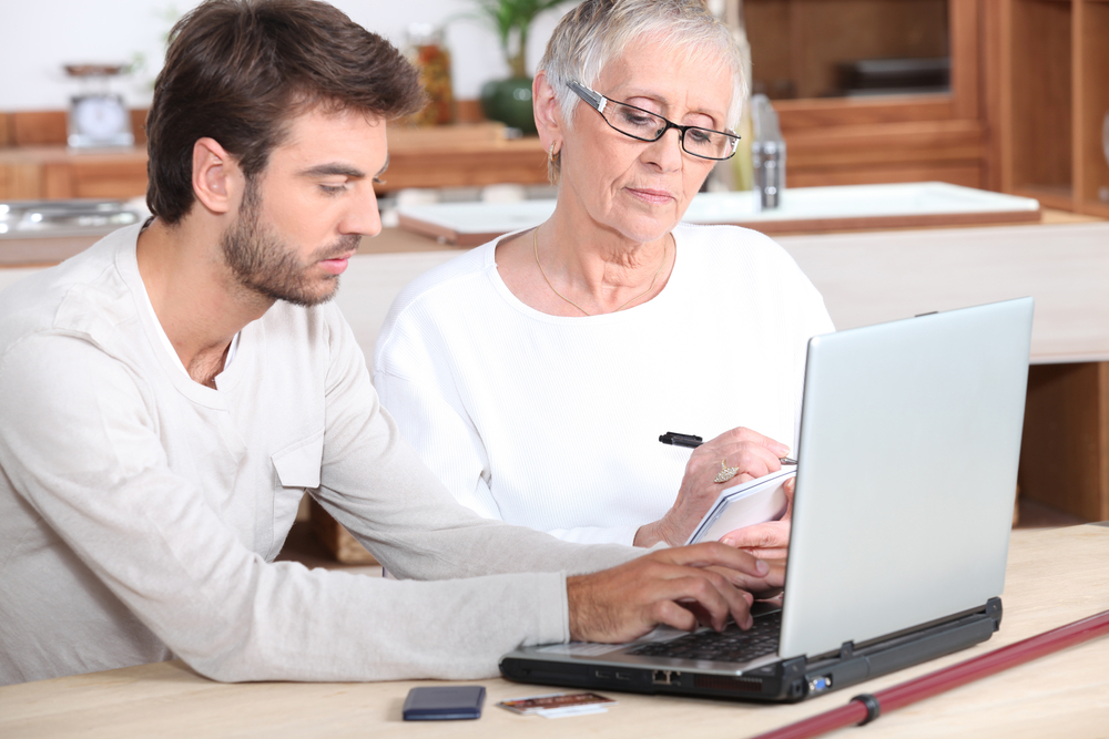 ict medewerker helpt oudere vrouw